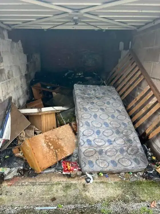 Garage full of old furniture and mattress waste